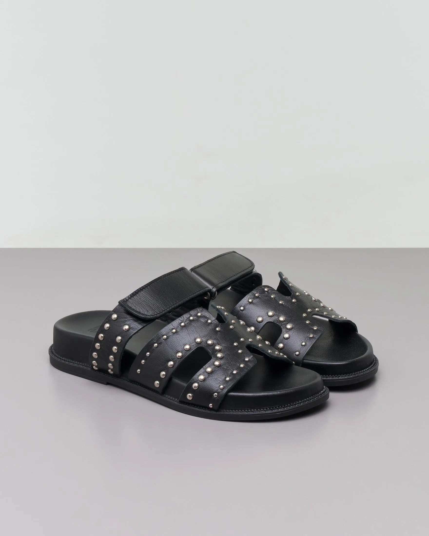 Sandali bassi neri in pelle con borchiette argento applicate sulla fibbia con chiusura a strappo