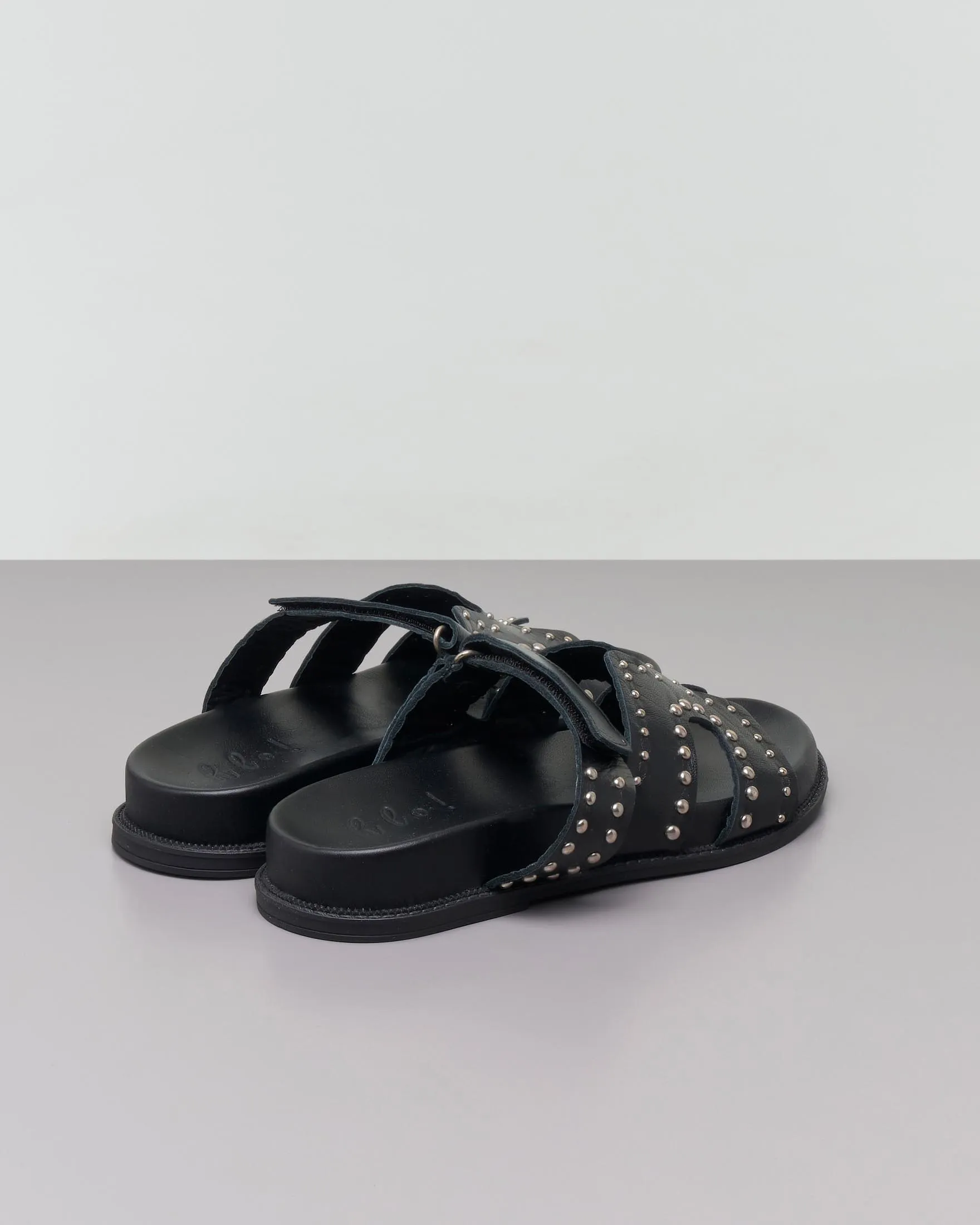 Sandali bassi neri in pelle con borchiette argento applicate sulla fibbia con chiusura a strappo